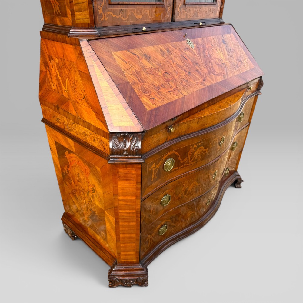 A mid-18th-century Italian Venetian bureau bookcase featuring detailed marquetry inlay, arched glazed doors, a slant-front writing desk, and three serpentine lower drawers. View VIII