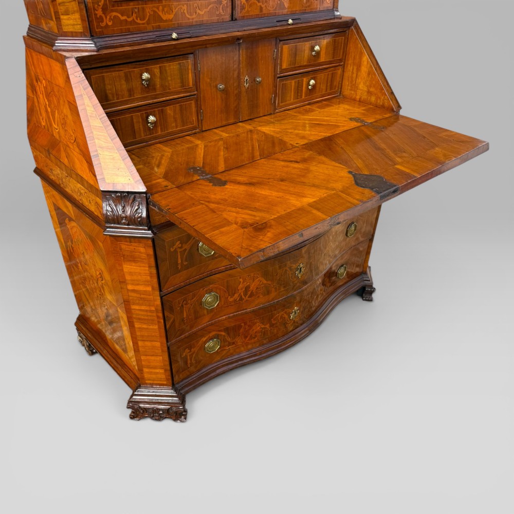 A mid-18th-century Italian Venetian bureau bookcase featuring detailed marquetry inlay, arched glazed doors, a slant-front writing desk, and three serpentine lower drawers. View IX