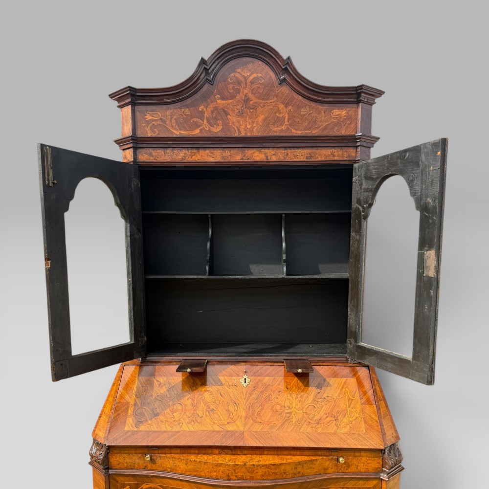 A mid-18th-century Italian Venetian bureau bookcase featuring detailed marquetry inlay, arched glazed doors, a slant-front writing desk, and three serpentine lower drawers. View XI