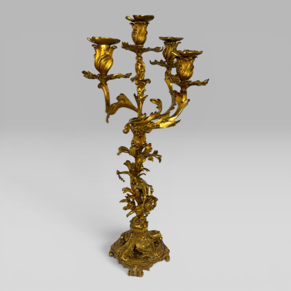 A pair of late nineteenth-century French Rococo gilt bronze candelabra with figural stems, scrolling floral arms, and ornate bases. View IV