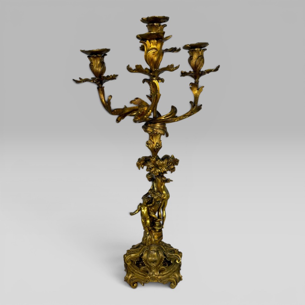 A pair of late nineteenth-century French Rococo gilt bronze candelabra with figural stems, scrolling floral arms, and ornate bases. View VI