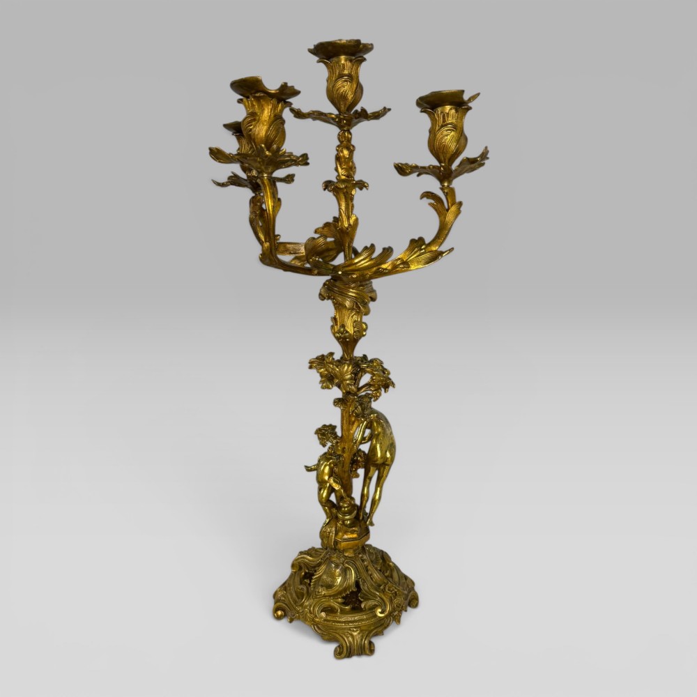 A pair of late nineteenth-century French Rococo gilt bronze candelabra with figural stems, scrolling floral arms, and ornate bases. View VII