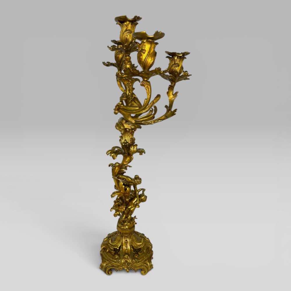 A pair of late nineteenth-century French Rococo gilt bronze candelabra with figural stems, scrolling floral arms, and ornate bases. View VIII