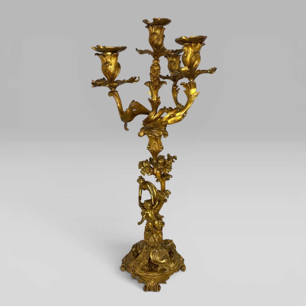 A pair of late nineteenth-century French Rococo gilt bronze candelabra with figural stems, scrolling floral arms, and ornate bases. View IX