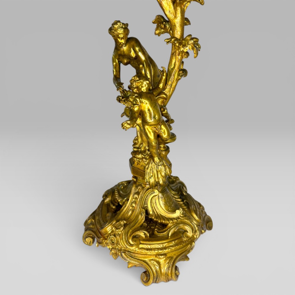 A pair of late nineteenth-century French Rococo gilt bronze candelabra with figural stems, scrolling floral arms, and ornate bases. View X