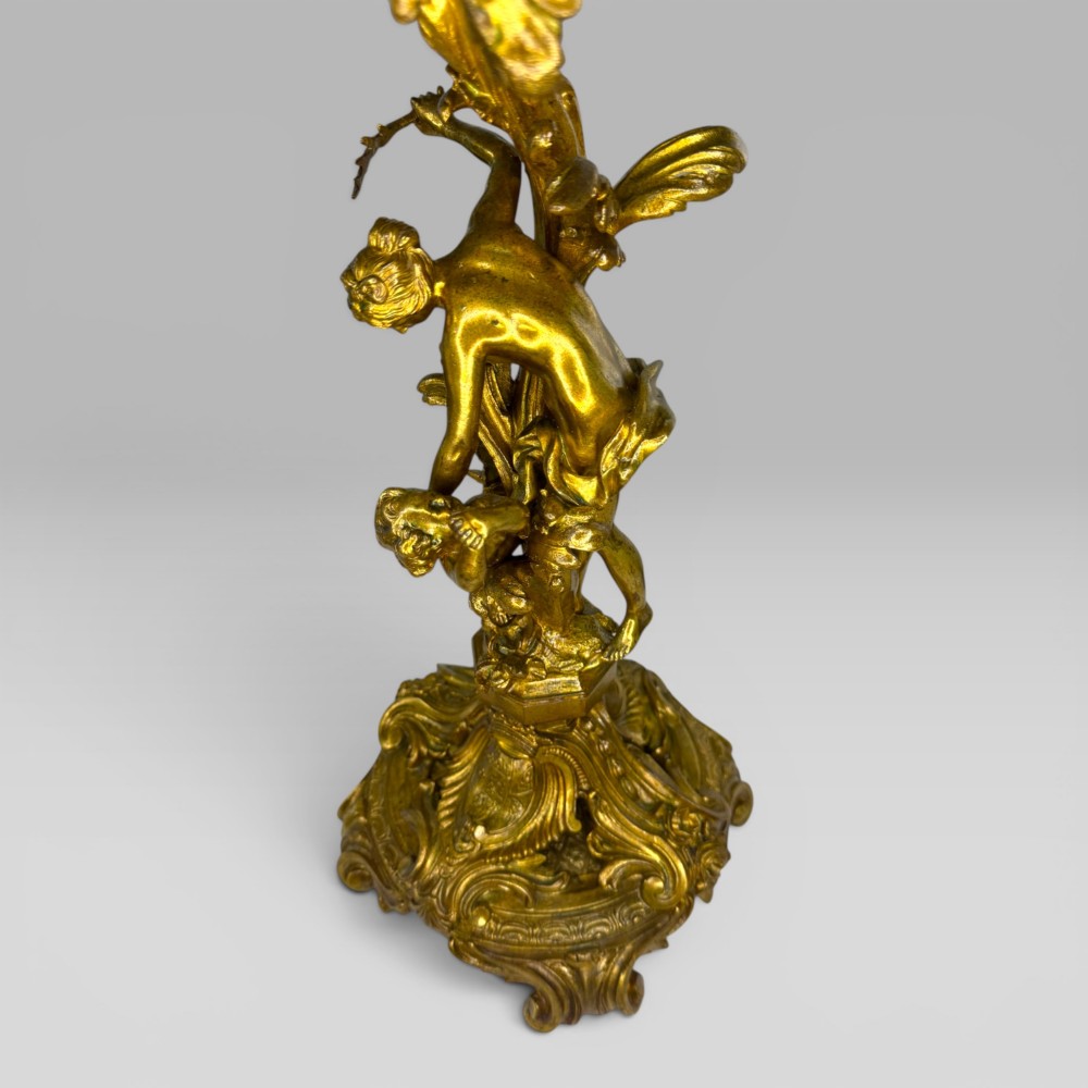 A pair of late nineteenth-century French Rococo gilt bronze candelabra with figural stems, scrolling floral arms, and ornate bases. View XI