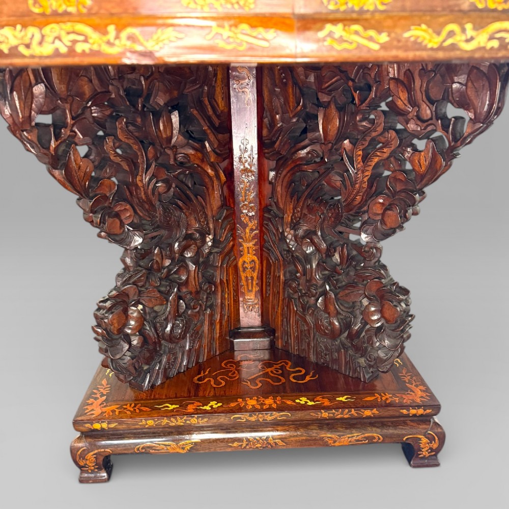 Circular rosewood centre table featuring detailed marquetry depictions of ships, pagodas, and floral motifs resting on a square inlaid pedestal base. View VI