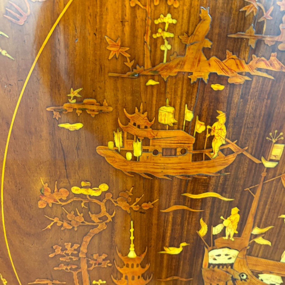 Circular rosewood centre table featuring detailed marquetry depictions of ships, pagodas, and floral motifs resting on a square inlaid pedestal base. View XI