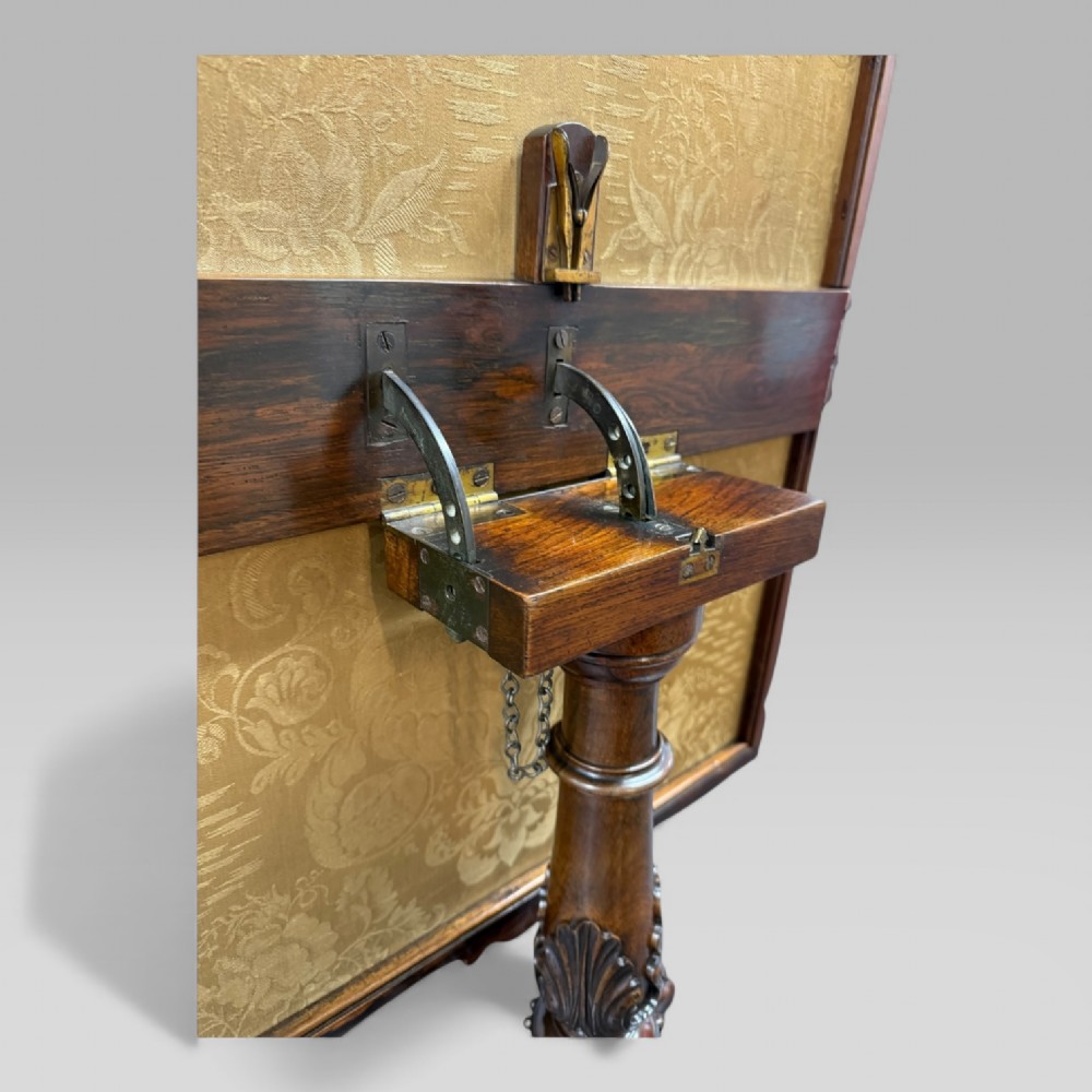 A William IV rosewood tilt-top tripod table featuring a shaped, carved frame housing a glazed needlepoint panel above a carved column and splayed tripod legs. View XI