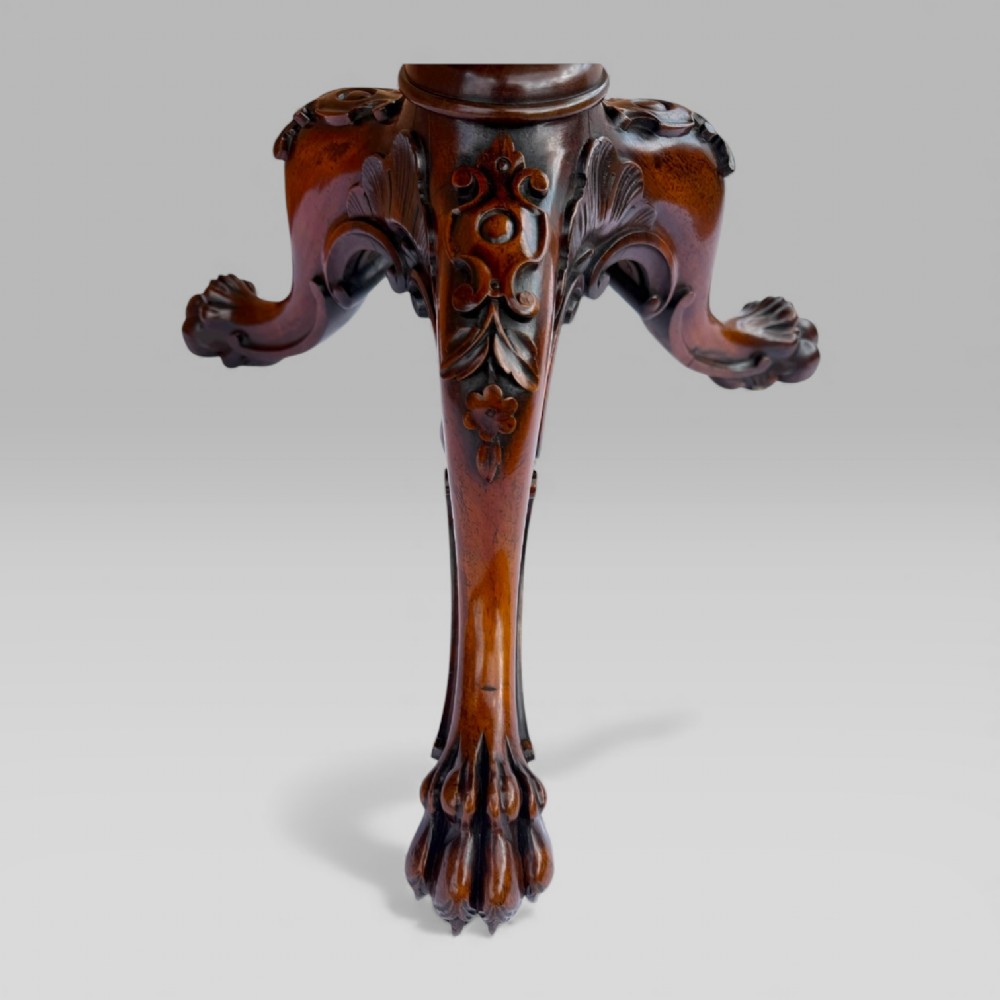 A William IV rosewood tilt-top tripod table featuring a shaped, carved frame housing a glazed needlepoint panel above a carved column and splayed tripod legs. View XII