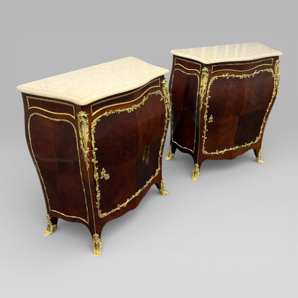 A pair of late 19th-century French kingwood bombe cabinets featuring ornate gilt-bronze mounts, curved fronts, and pale marble tops. View III