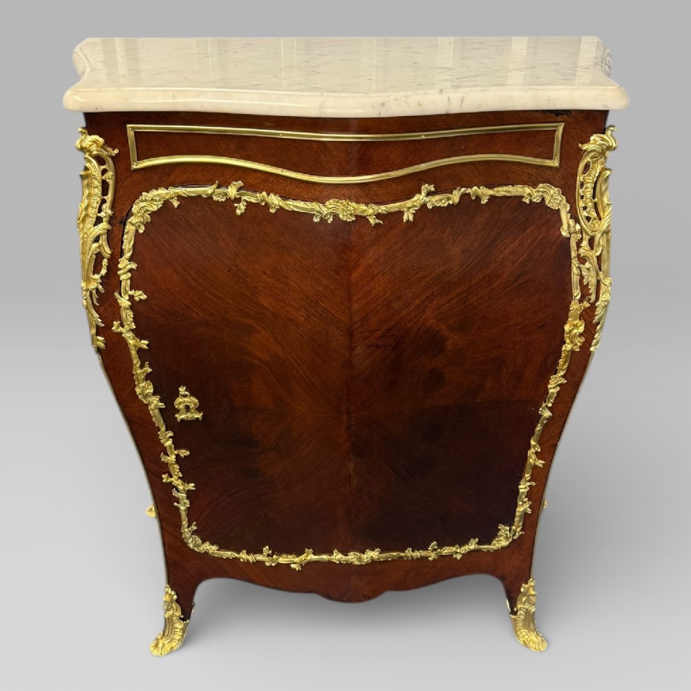 A pair of late 19th-century French kingwood bombe cabinets featuring ornate gilt-bronze mounts, curved fronts, and pale marble tops. View VII