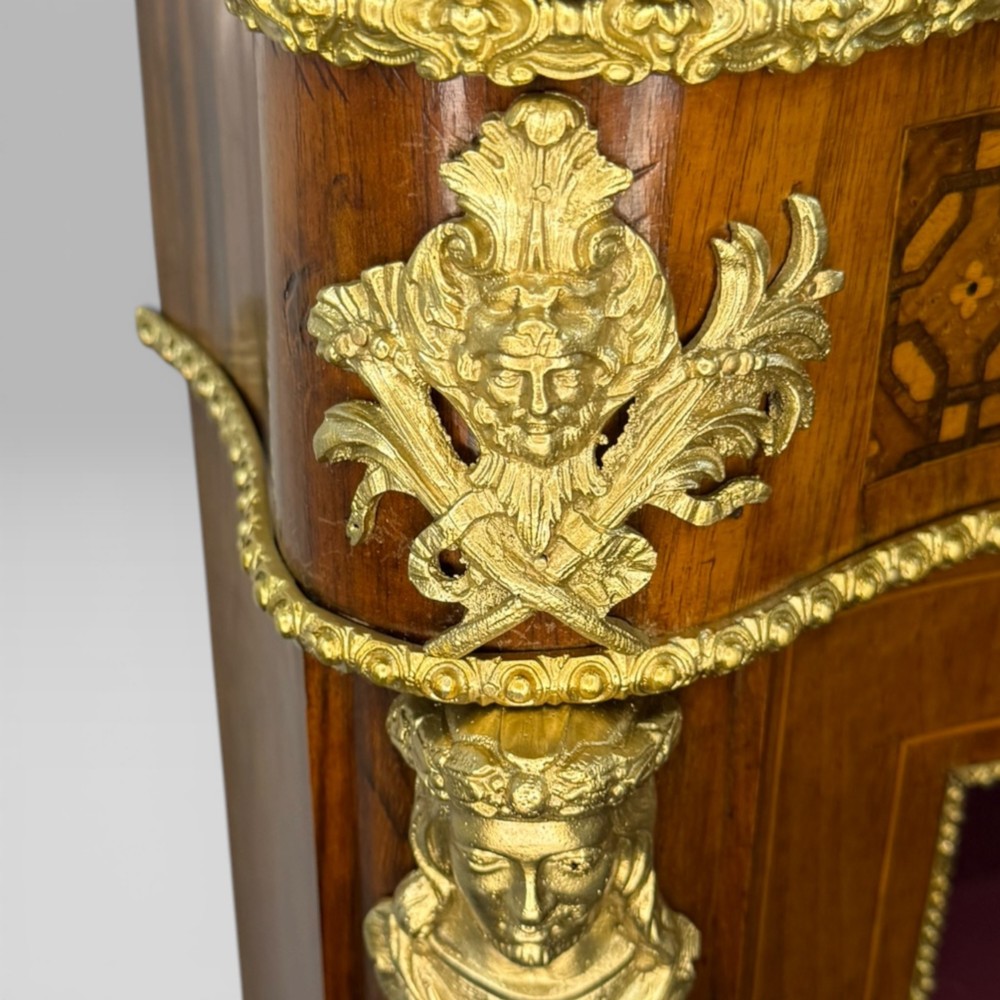 A Victorian walnut serpentine credenza featuring geometric marquetry, gilt ormolu mounts, a central panel door, and two curved glass side doors revealing lined display shelves. View VIII
