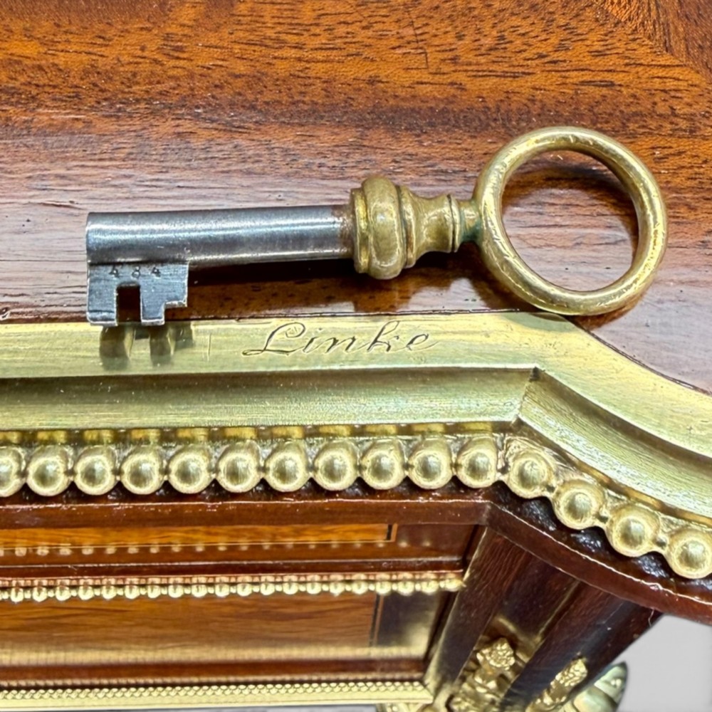 A Louis XVI style mahogany and parquetry writing desk featuring a dark leather top, gilt-bronze mounts, five drawers, and fluted tapered legs. View V