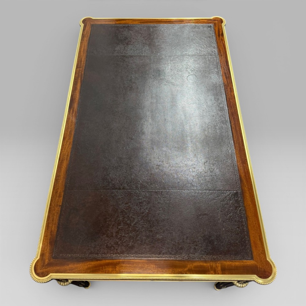 A Louis XVI style mahogany and parquetry writing desk featuring a dark leather top, gilt-bronze mounts, five drawers, and fluted tapered legs. View X