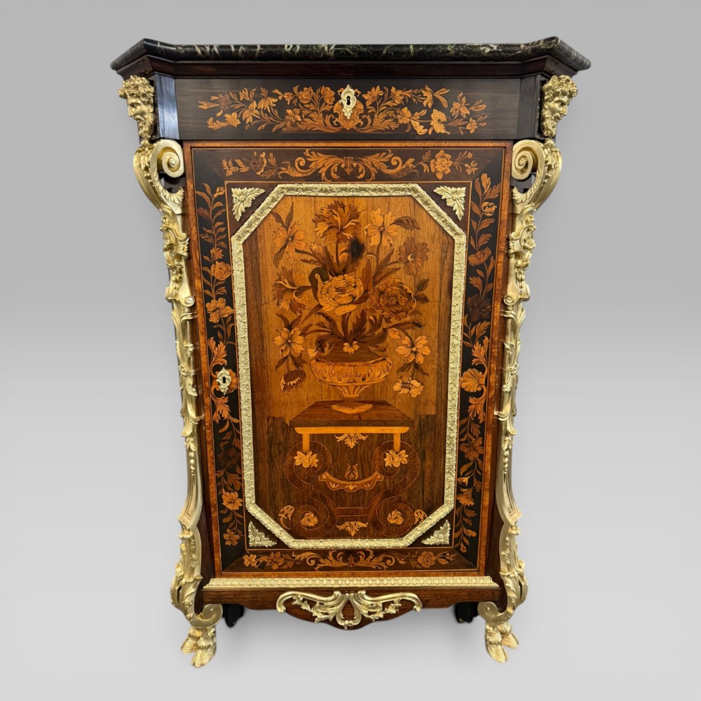 A nineteenth-century dark wood pier cabinet featuring detailed floral marquetry, polished gilt-bronze mounts, classical mask figures, and a black marble top. View II