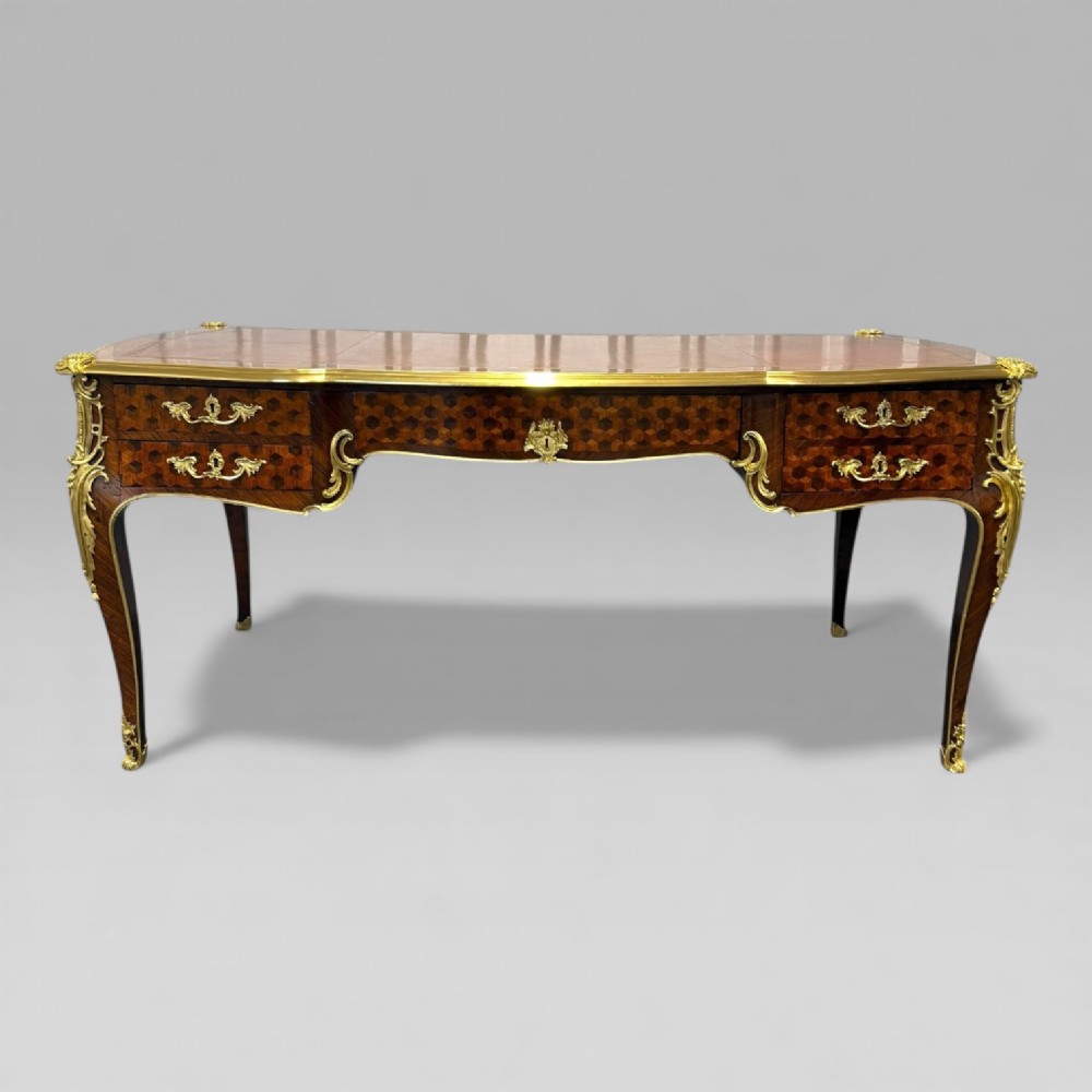 A late nineteenth-century French kingwood bureau plat featuring parquetry veneers, gilt bronze ormolu mounts, cabriole legs, and a brown leather inset writing surface. View II