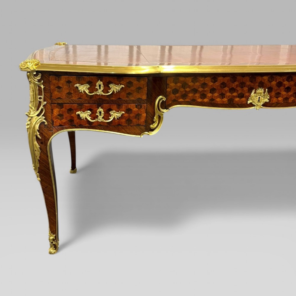 A late nineteenth-century French kingwood bureau plat featuring parquetry veneers, gilt bronze ormolu mounts, cabriole legs, and a brown leather inset writing surface. View IV