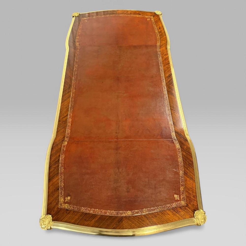 A late nineteenth-century French kingwood bureau plat featuring parquetry veneers, gilt bronze ormolu mounts, cabriole legs, and a brown leather inset writing surface. View VII