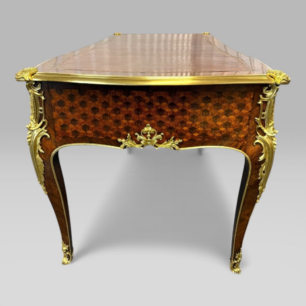 A late nineteenth-century French kingwood bureau plat featuring parquetry veneers, gilt bronze ormolu mounts, cabriole legs, and a brown leather inset writing surface. View VIII