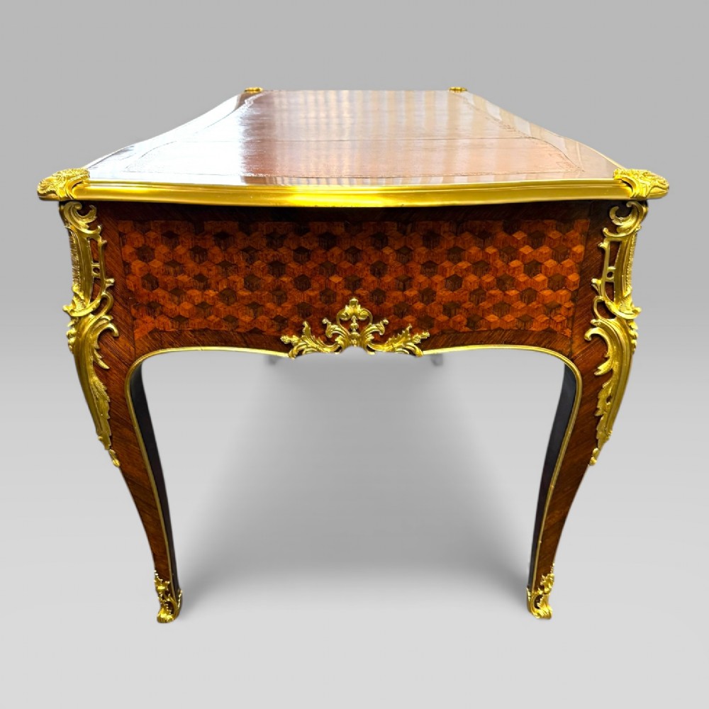 A late nineteenth-century French kingwood bureau plat featuring parquetry veneers, gilt bronze ormolu mounts, cabriole legs, and a brown leather inset writing surface. View IX