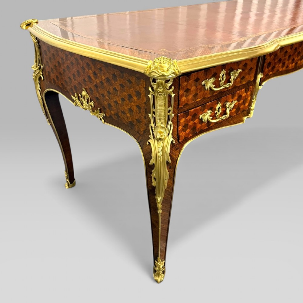 A late nineteenth-century French kingwood bureau plat featuring parquetry veneers, gilt bronze ormolu mounts, cabriole legs, and a brown leather inset writing surface. View XI