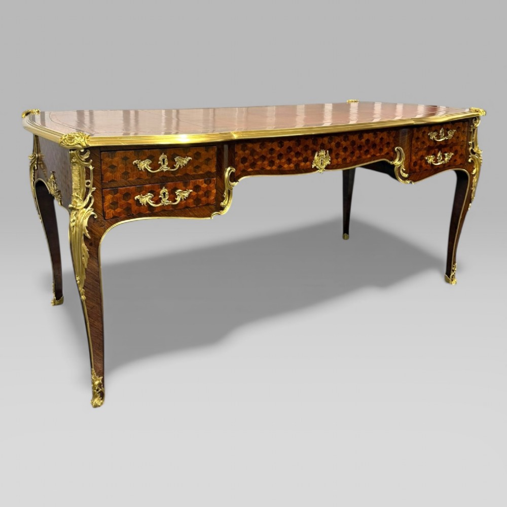 A late nineteenth-century French kingwood bureau plat featuring parquetry veneers, gilt bronze ormolu mounts, cabriole legs, and a brown leather inset writing surface. View XIII