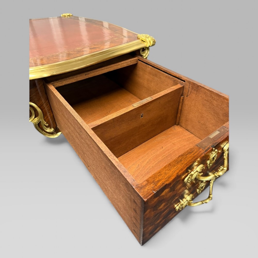 A late nineteenth-century French kingwood bureau plat featuring parquetry veneers, gilt bronze ormolu mounts, cabriole legs, and a brown leather inset writing surface. View XIV