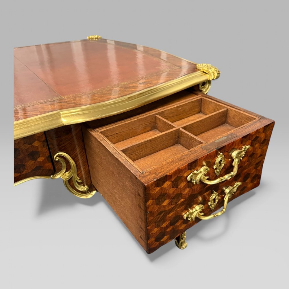 A late nineteenth-century French kingwood bureau plat featuring parquetry veneers, gilt bronze ormolu mounts, cabriole legs, and a brown leather inset writing surface. View XV