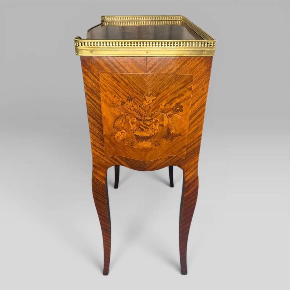 A French Louis XV style kingwood petite commode featuring three floral marquetry drawers, cabriole legs, and a brass gallery top. View VII