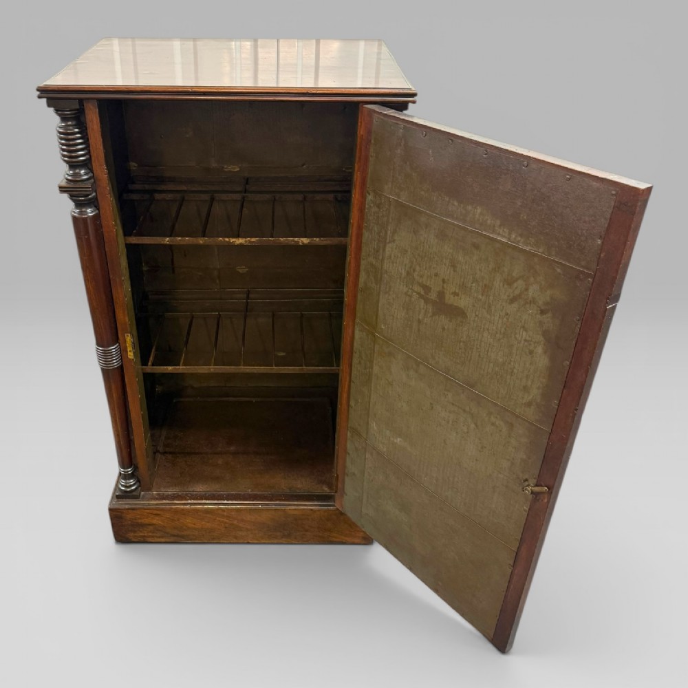 A Regency mahogany cellarette cabinet featuring reeded corner columns, a panelled door, and a flat top surface. View II