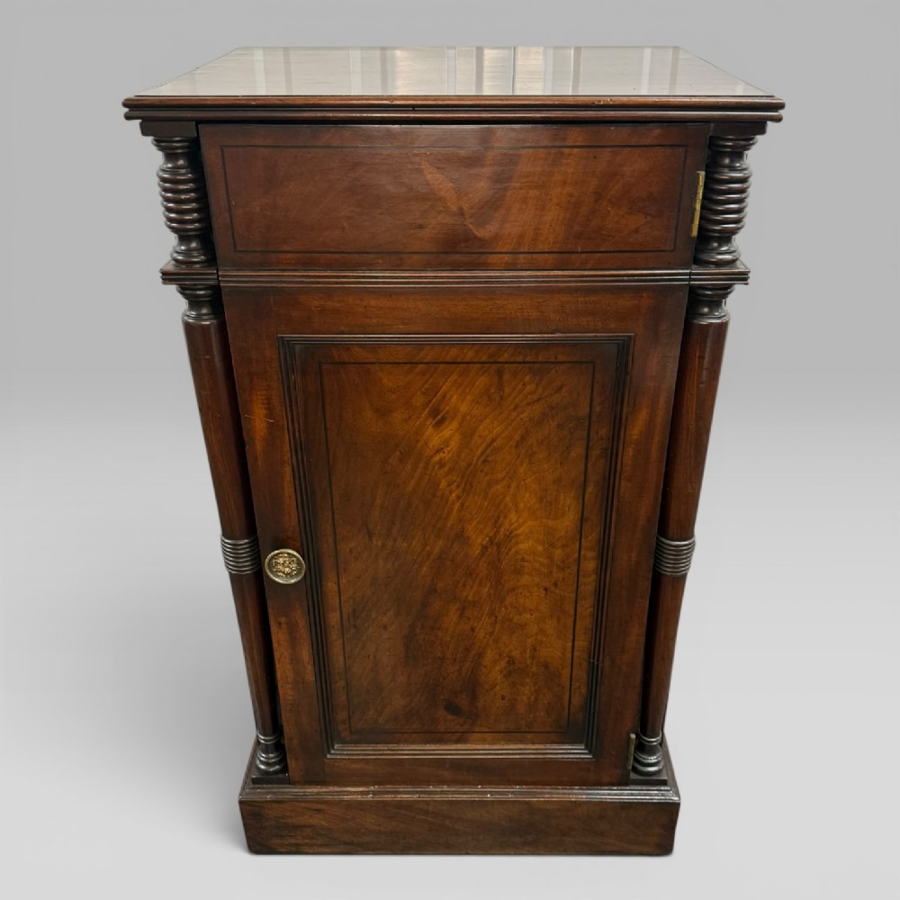 A Regency mahogany cellarette cabinet featuring reeded corner columns, a panelled door, and a flat top surface. View IV