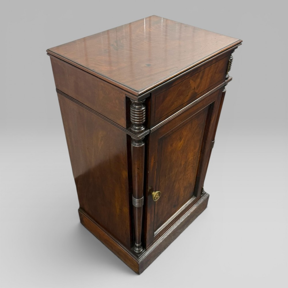 A Regency mahogany cellarette cabinet featuring reeded corner columns, a panelled door, and a flat top surface. View V