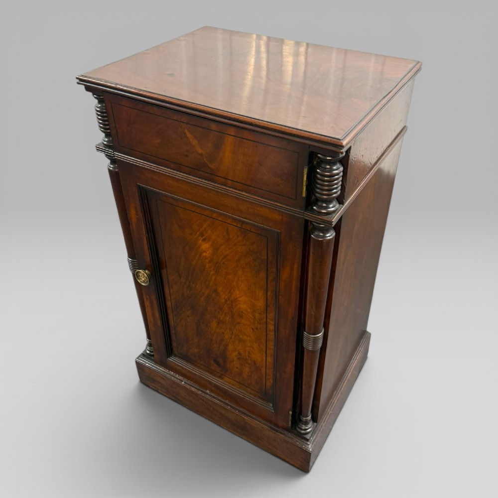 A Regency mahogany cellarette cabinet featuring reeded corner columns, a panelled door, and a flat top surface. View VII