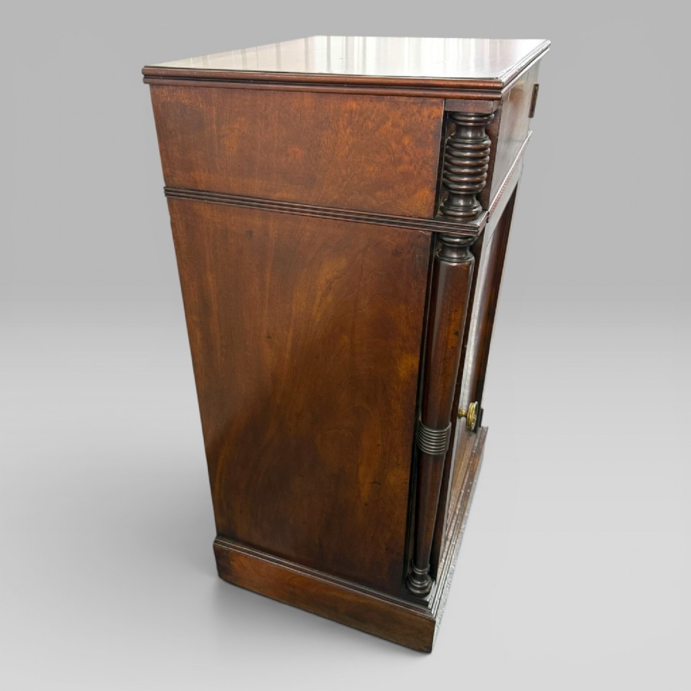 A Regency mahogany cellarette cabinet featuring reeded corner columns, a panelled door, and a flat top surface. View VIII
