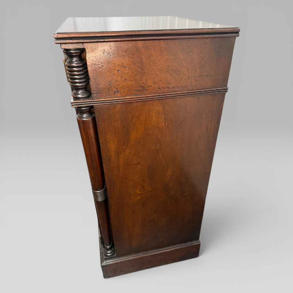 A Regency mahogany cellarette cabinet featuring reeded corner columns, a panelled door, and a flat top surface. View X