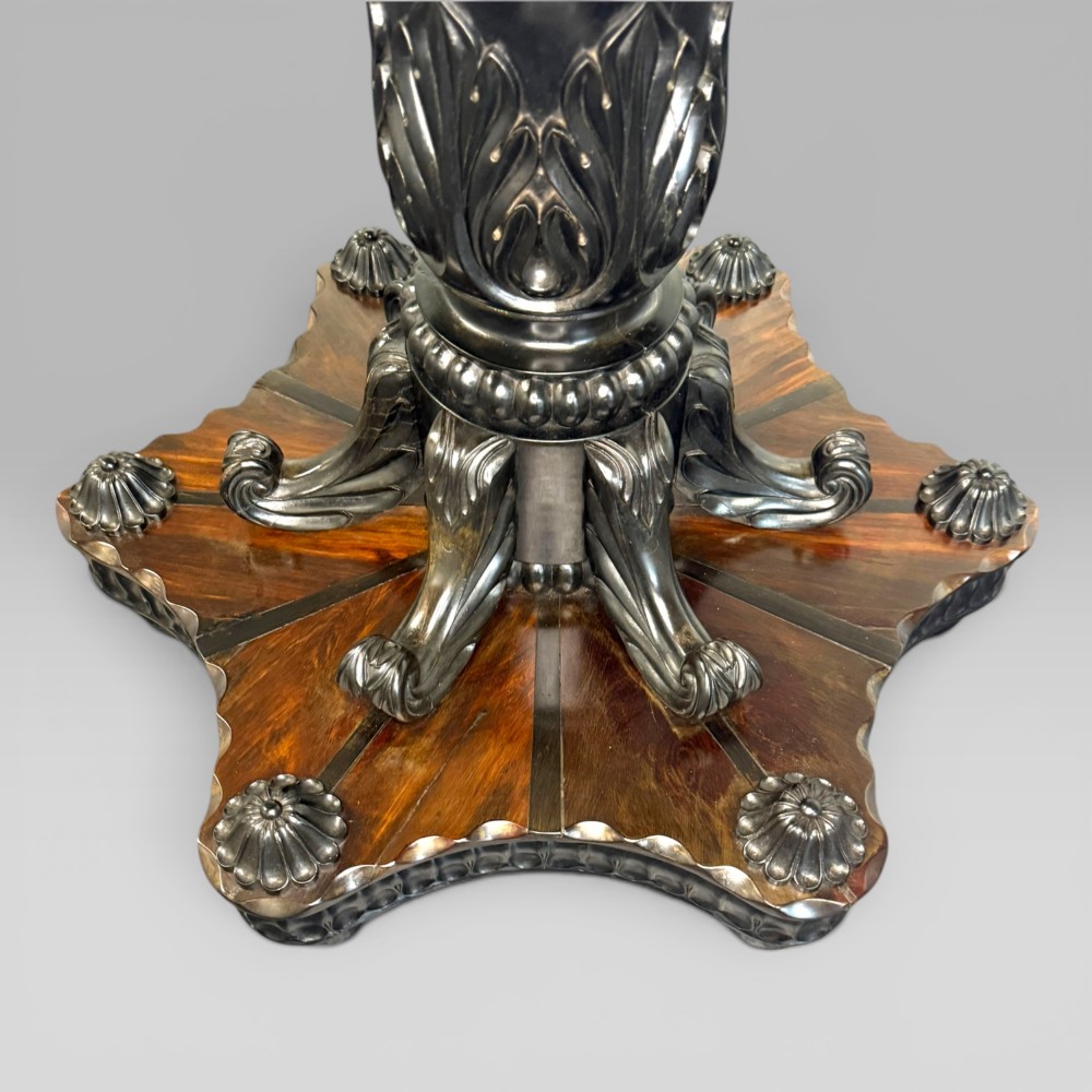 Overhead view of a circular centre table top showing radiating calamander wood veneers, light stringing, a central star motif, and a carved ebony border. View IV