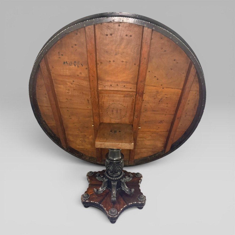 Overhead view of a circular centre table top showing radiating calamander wood veneers, light stringing, a central star motif, and a carved ebony border. View VI