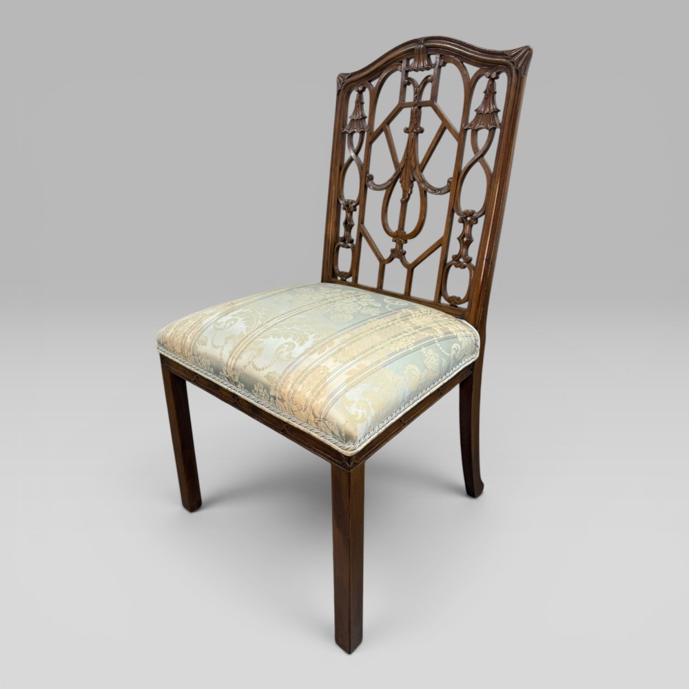 A Georgian Chippendale style dark walnut side chair with carved lattice fretwork on the backrest and a pale blue and gold striped damask seat.
