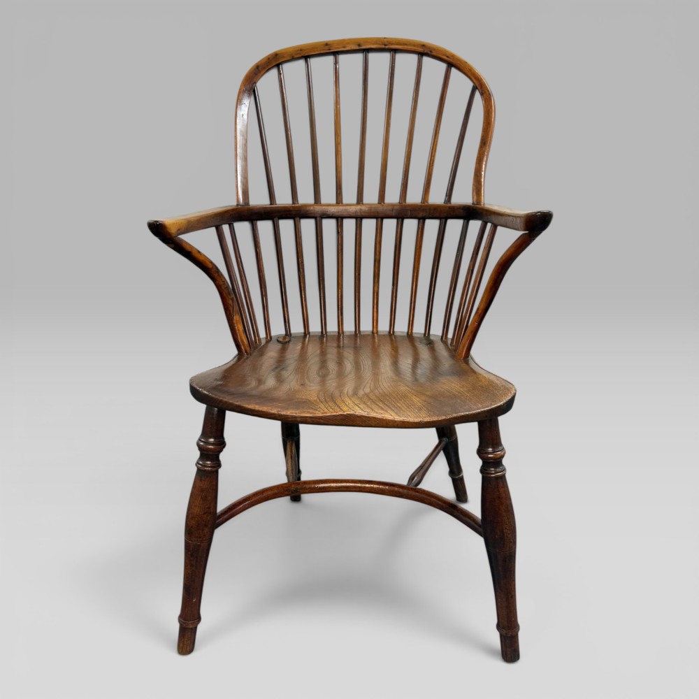An early nineteenth-century hoop-back Windsor armchair crafted from yew wood and elm with turned legs and a contoured saddle seat. View II