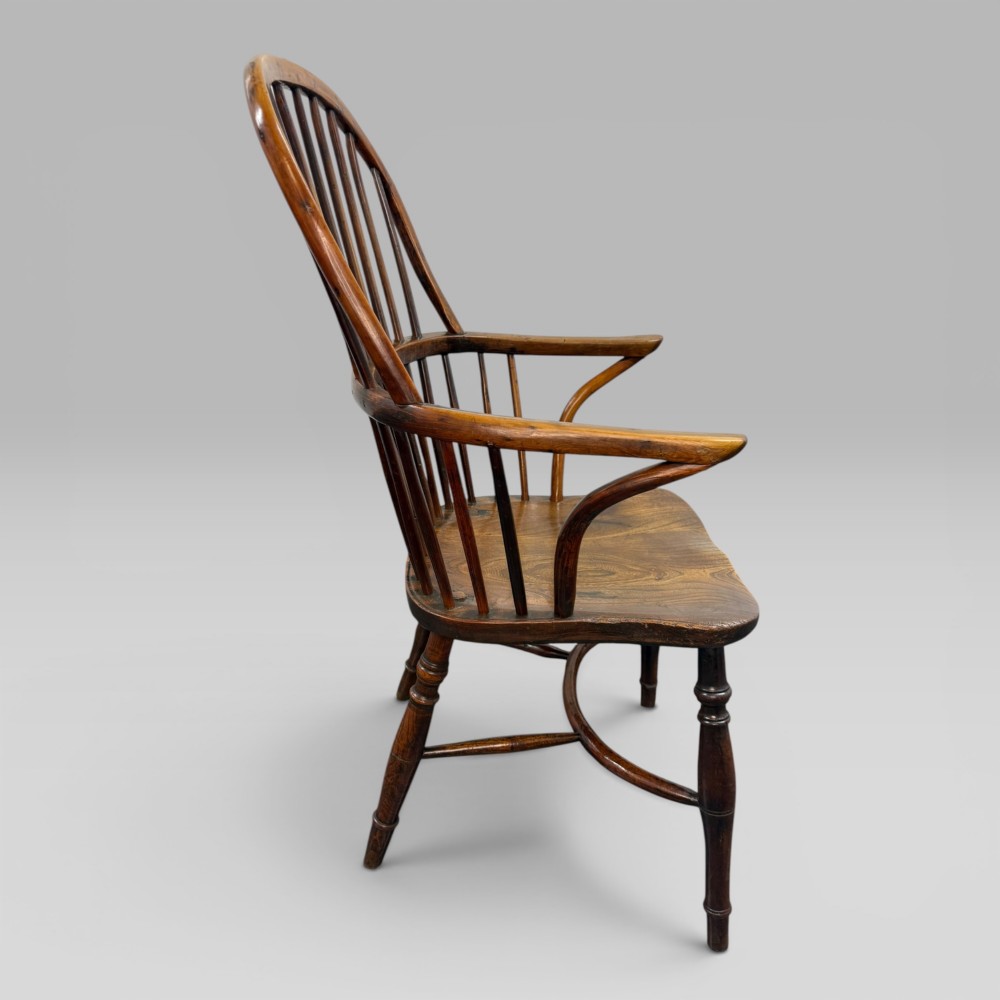 An early nineteenth-century hoop-back Windsor armchair crafted from yew wood and elm with turned legs and a contoured saddle seat. View IV
