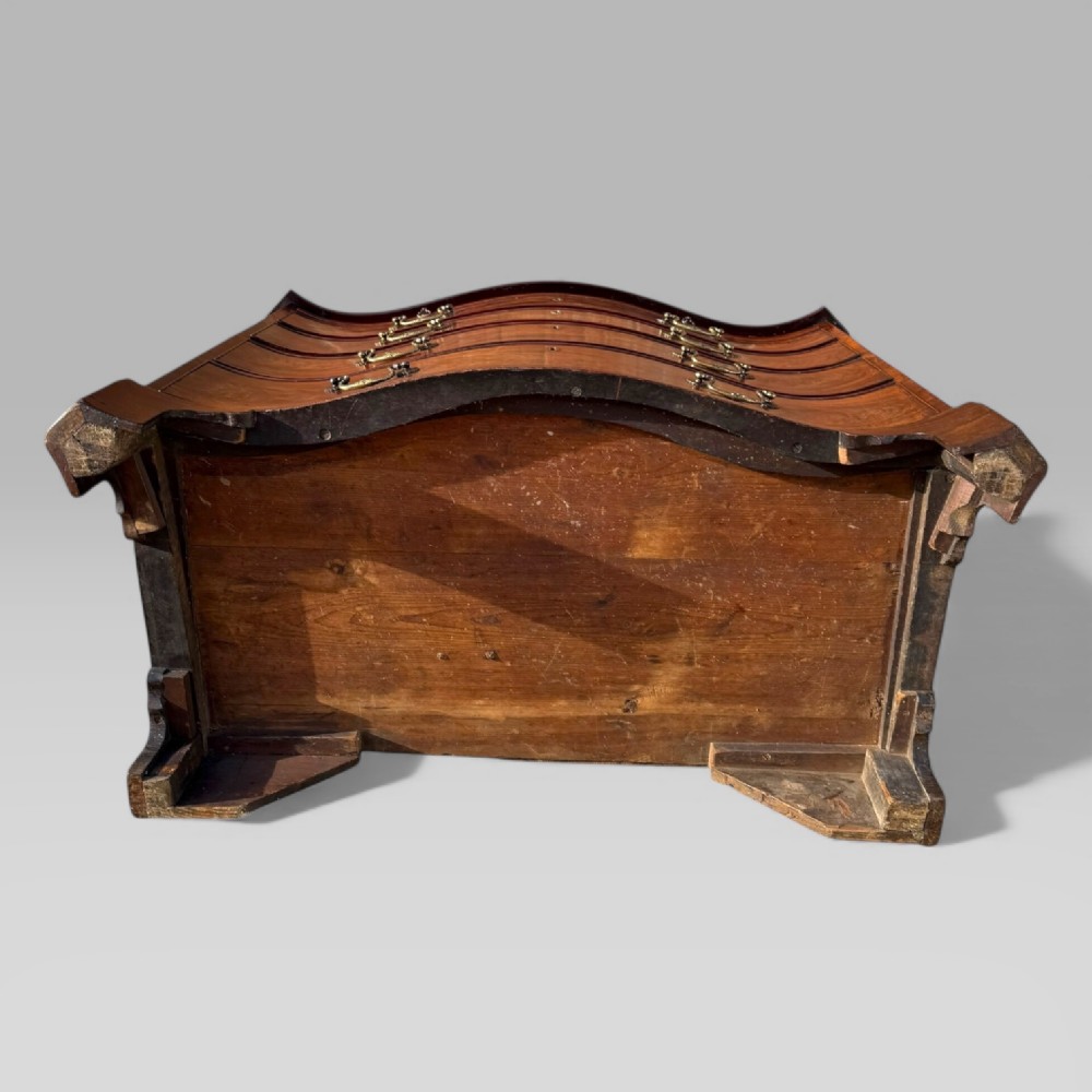 An 18th-century Georgian mahogany chest of drawers featuring a curved serpentine front, four graduated drawers, brass swan-neck handles, and a pull-out brushing slide. View XIV