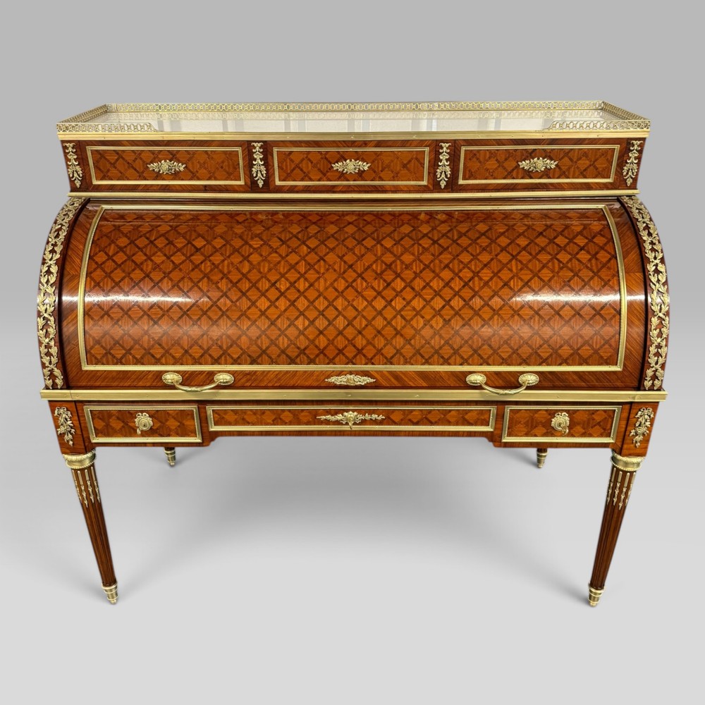 A French Louis XVI style cylinder desk featuring detailed geometric diamond parquetry, gilded bronze mounts, a top brass gallery rail, and slender fluted legs. View II