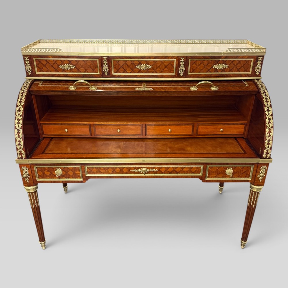 A French Louis XVI style cylinder desk featuring detailed geometric diamond parquetry, gilded bronze mounts, a top brass gallery rail, and slender fluted legs. View V