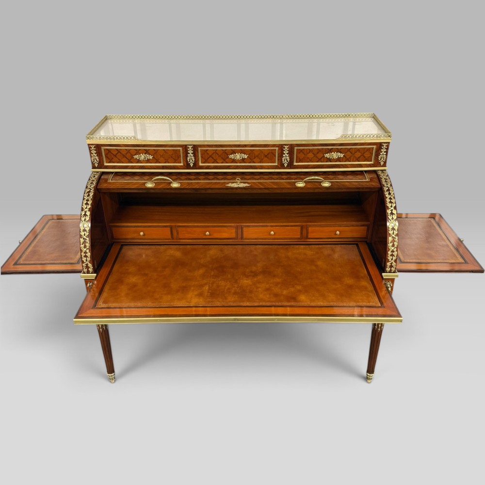 A French Louis XVI style cylinder desk featuring detailed geometric diamond parquetry, gilded bronze mounts, a top brass gallery rail, and slender fluted legs. View VI