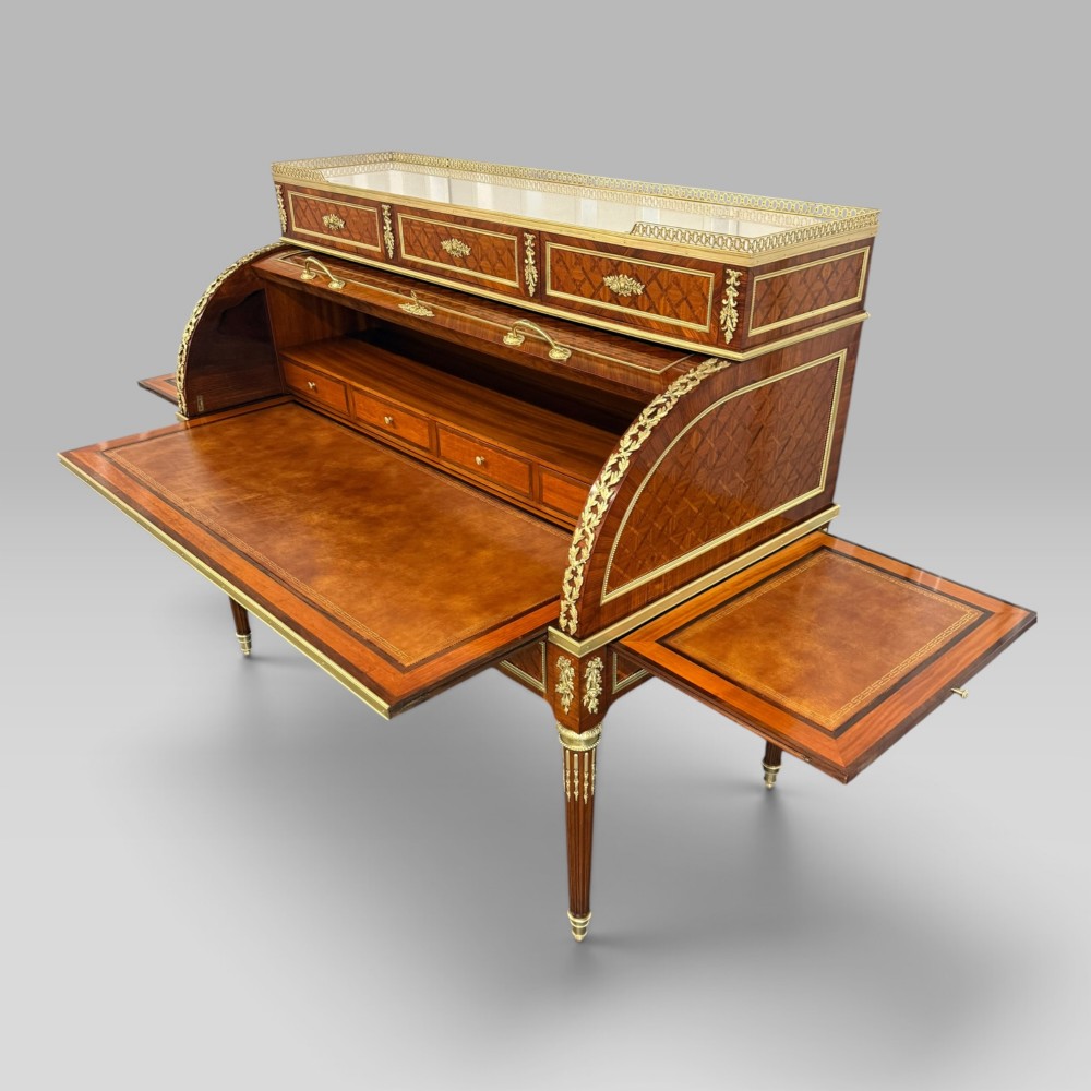 A French Louis XVI style cylinder desk featuring detailed geometric diamond parquetry, gilded bronze mounts, a top brass gallery rail, and slender fluted legs. View VIII