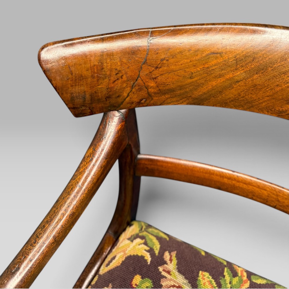 An antique William IV mahogany elbow armchair featuring scrolled armrests, turned front legs, and a floral tapestry upholstered seat. View VII