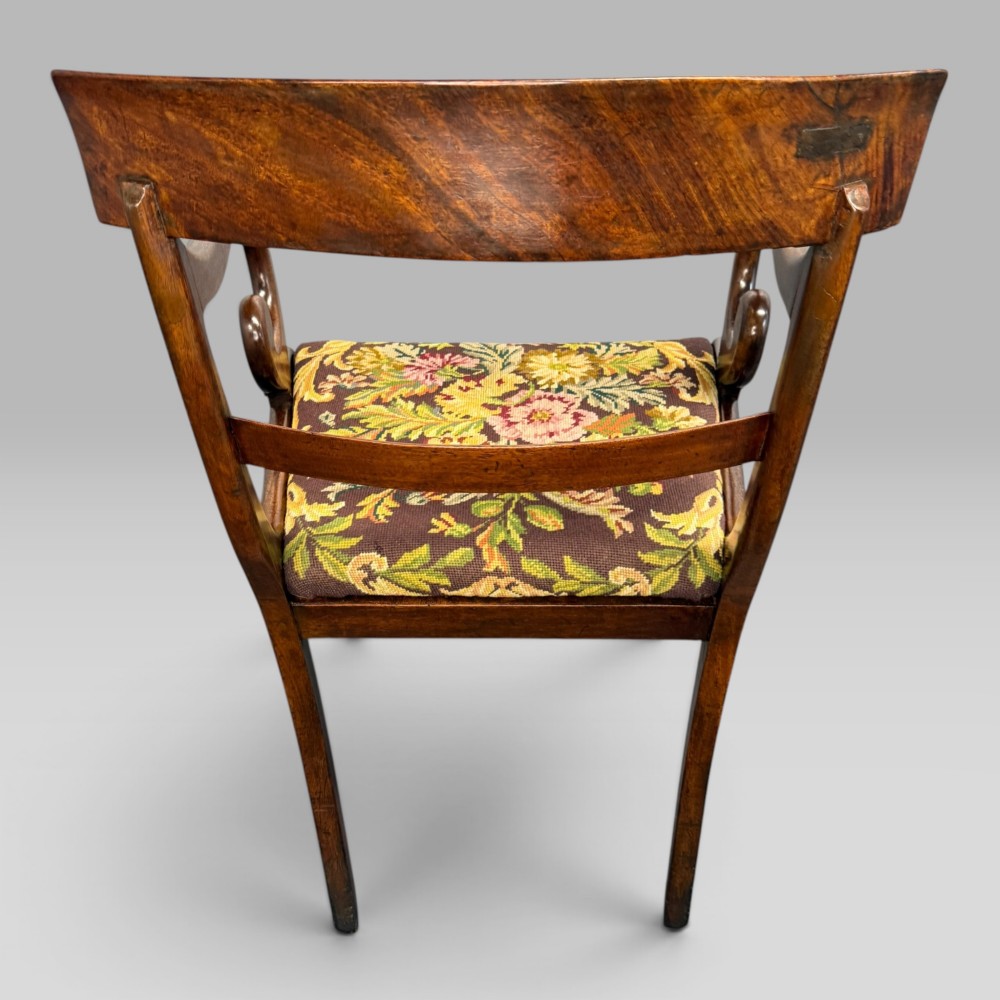 An antique William IV mahogany elbow armchair featuring scrolled armrests, turned front legs, and a floral tapestry upholstered seat. View IX