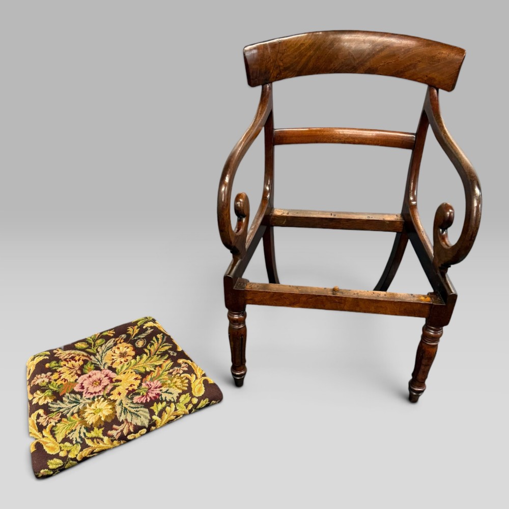 An antique William IV mahogany elbow armchair featuring scrolled armrests, turned front legs, and a floral tapestry upholstered seat. View X