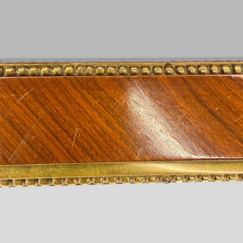 A rectangular French Louis XVI style bijouterie display table featuring a glazed glass top, decorative gilt bronze mounts along the frieze, and slender tapered legs ending in brass sabots. View XII
